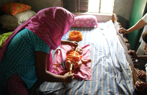 A woman measures a baby.