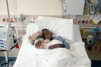 Child sleeping in hospital bed.