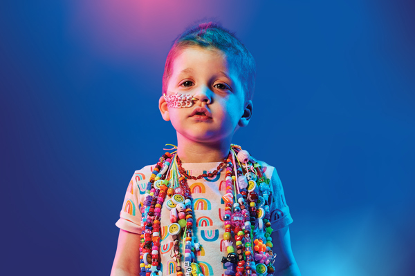 A young child wearing colourful bravery beads around her neck.