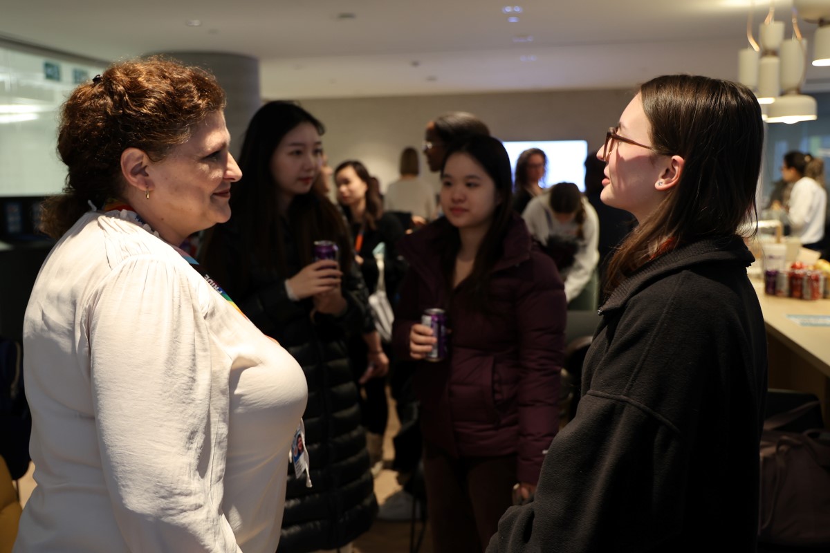 People chatting and holding drinks at a social or networking event.