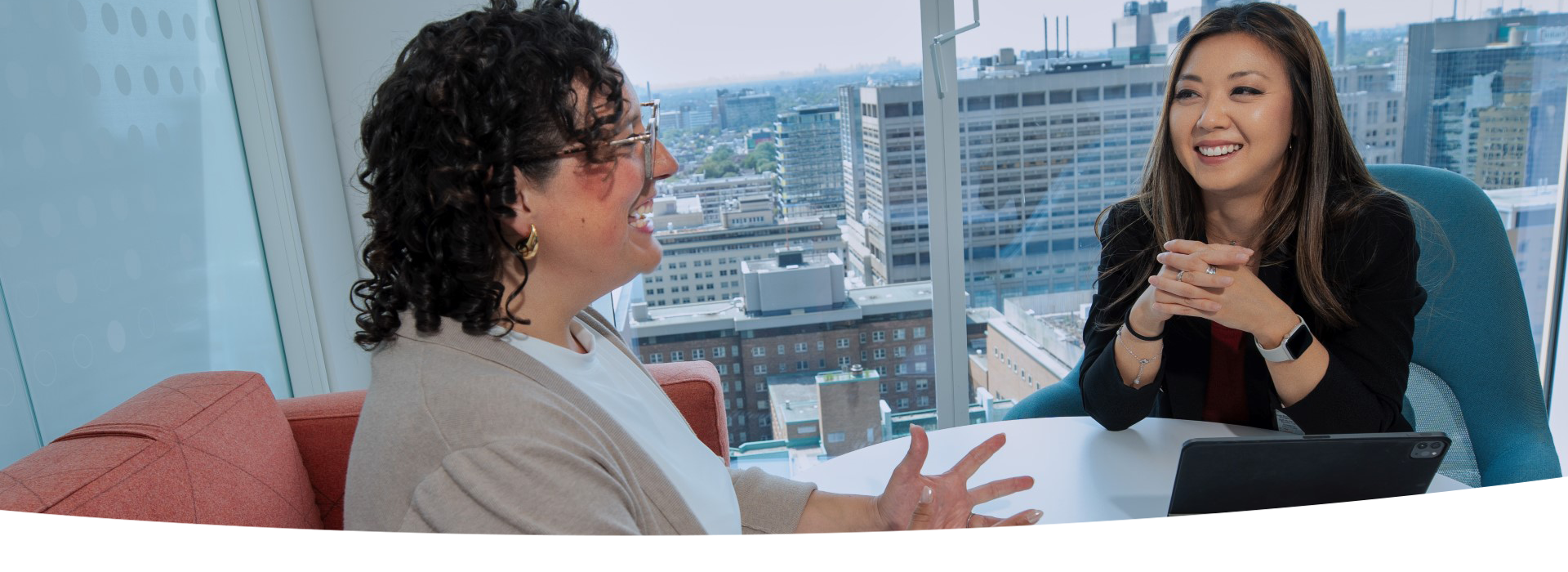 Two women seated at a table having a conversation.