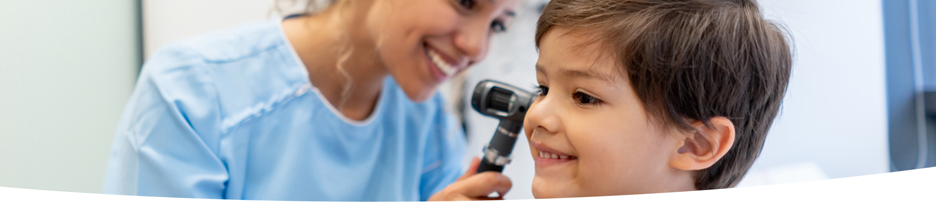 Boy getting his ear checked by a doctor