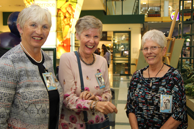 Three women stand side by side wearing name badges.