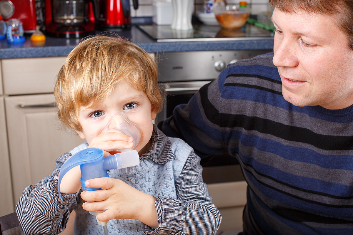 A child holding a Positive Expiratory Pressure mask up to their mouth