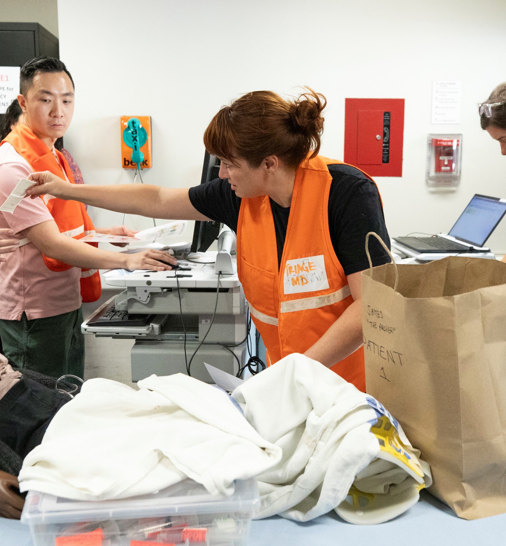 A simulated patient arrives in the ambulance bay at SickKids as two nurses and an ED physician triage them.