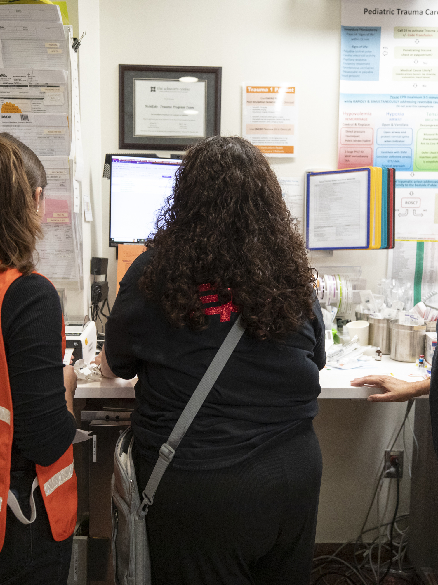 Andrea Boysen, right, and other staff work at a computer station to register simulated patients as they arrive.
